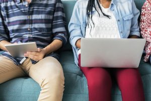 Two people sitting side by side using a laptop and a tablet, helping Colorado adults succeed.