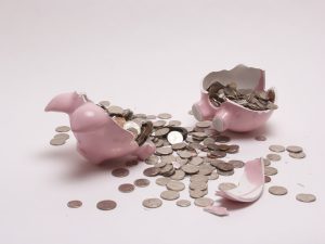 Broken piggy bank with coins spilled out, symbolizing the urgency for the Colorado Secure Savings Plan debated in HB17-1290 testimony.