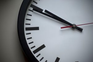 Analog wall clock showing a close-up of the hands and part of the clock face, symbolizing Colorado's Fiscal Time Bomb.