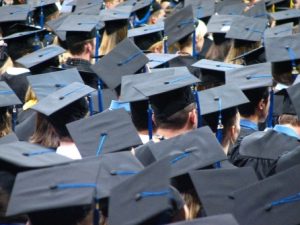 Graduation caps worn by students at a commencement ceremony, symbolizing the fallout of recent education policy changes.