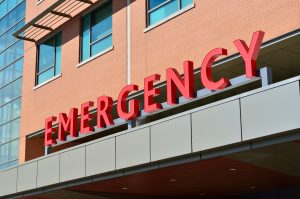 Red "emergency" sign on the exterior of a Colorado hospital building.