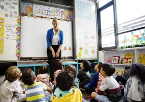 Teacher addressing a group of young students in a colorful classroom, as part of strengthening Colorado's ECE workforce.