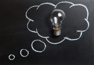 Light bulb on a chalkboard with a thought bubble drawn around it, symbolizing financial well-being.