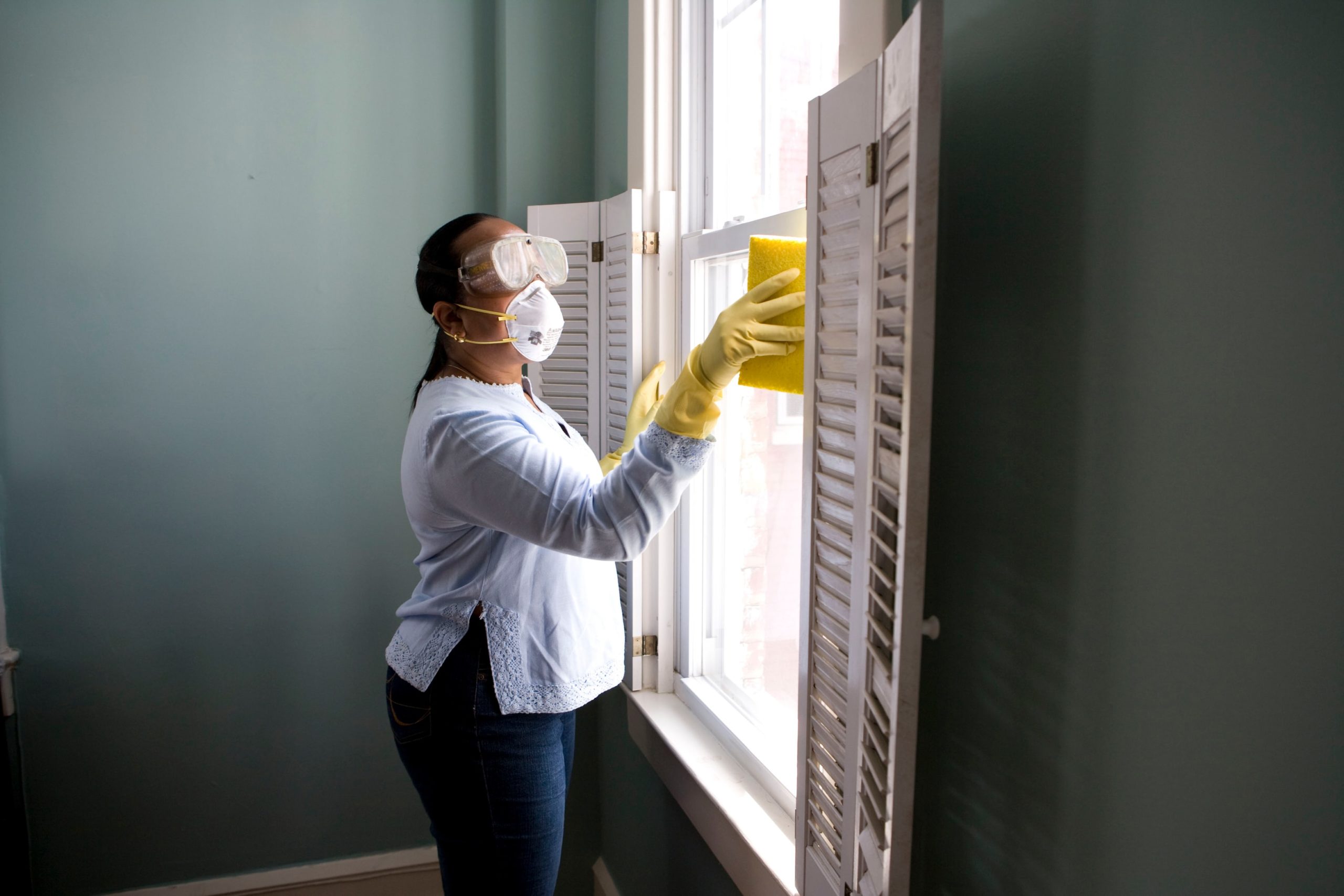 woman cleaning with mask and gloves COVID