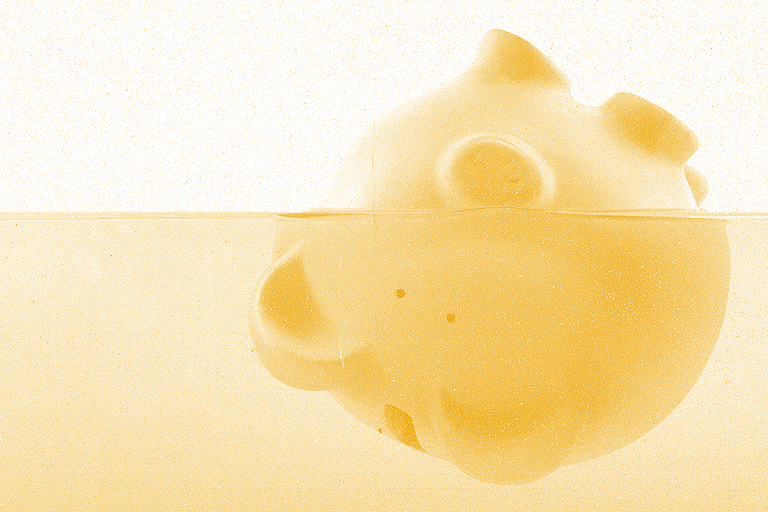 Debt-ridden gummy bear submerged in liquid with bubbles, creating a split view above and below the surface.