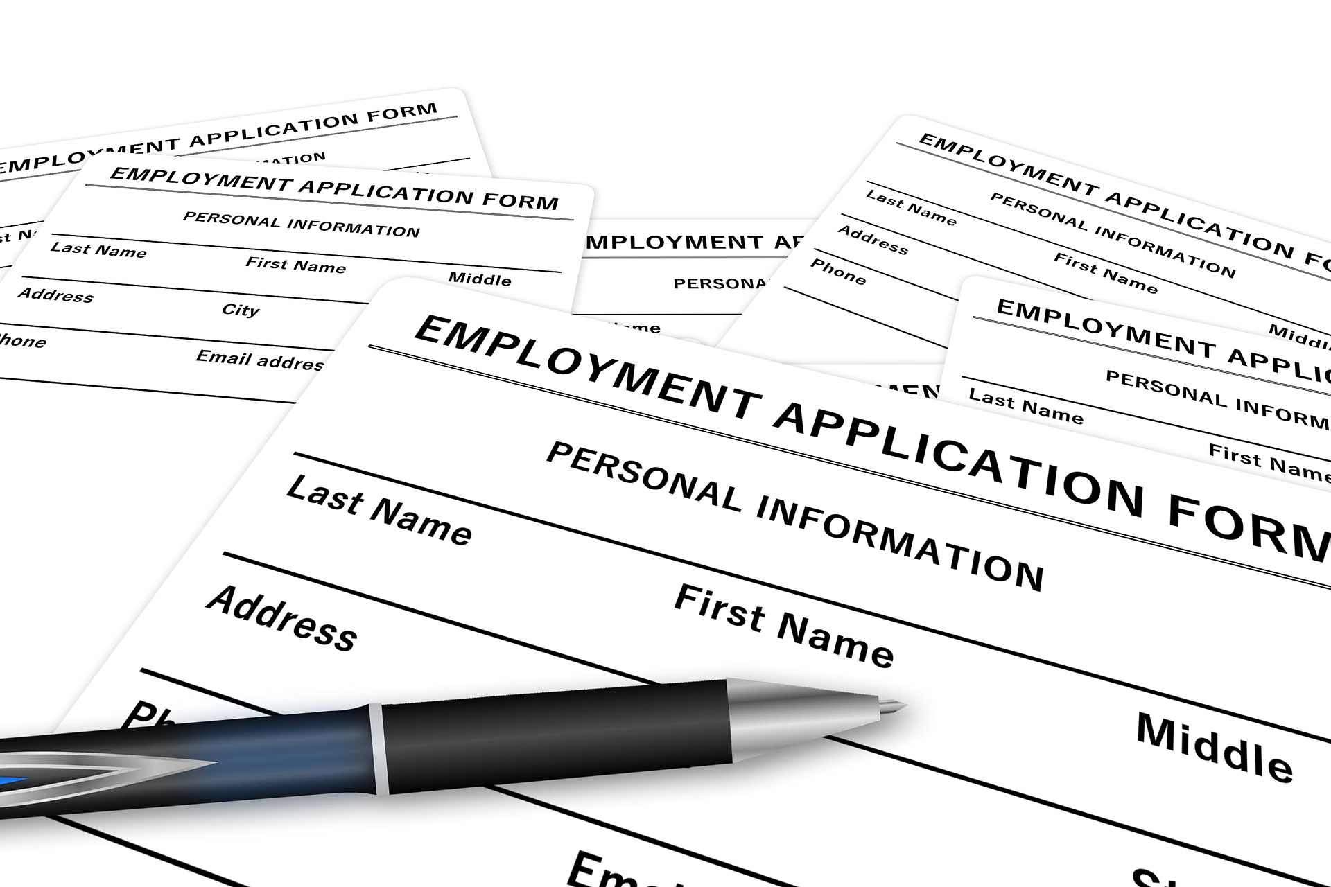 Multiple blank employment application forms, a pen, and SB20-207 information regarding Colorado's recovery and unemployment insurance.