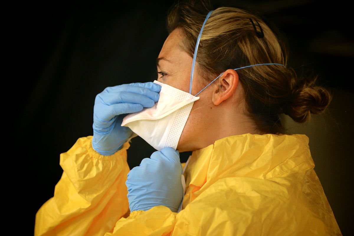 Woman in yellow with mask and gloves (future of work: COVID''s impact on women)