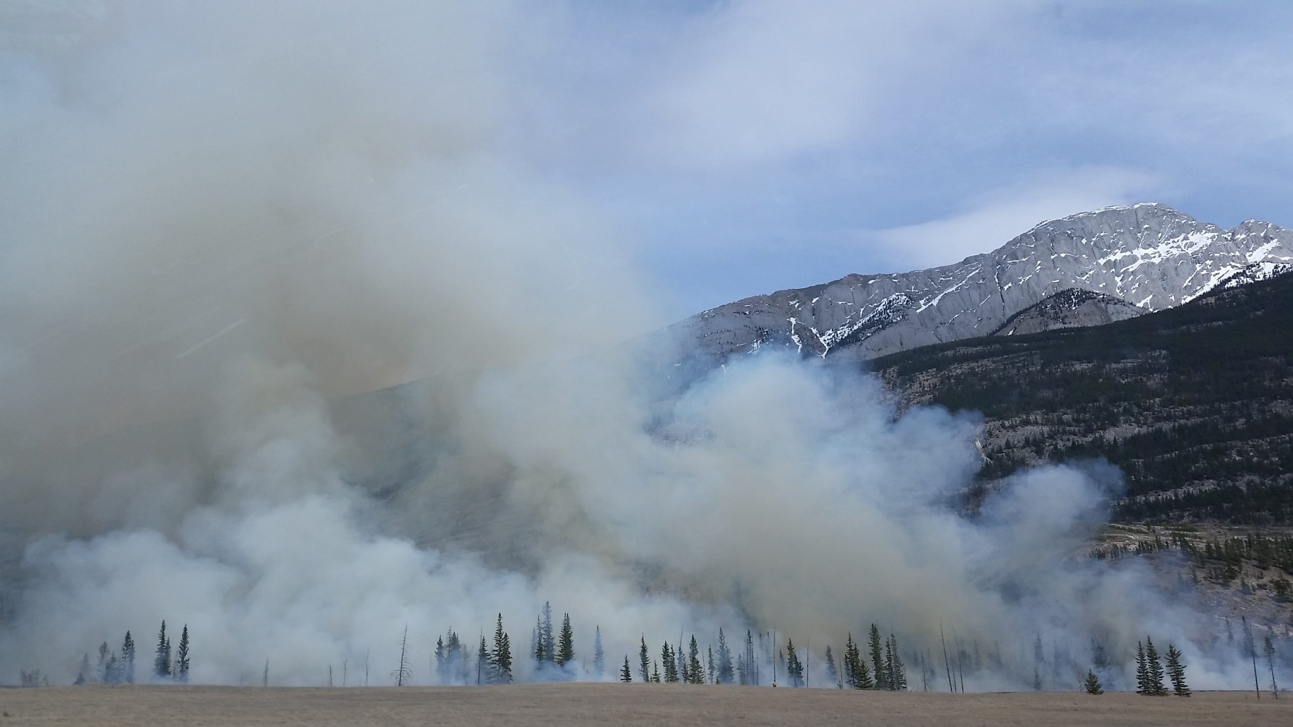 Climate Change-induced wildfire smoke obscuring a mountainous landscape.